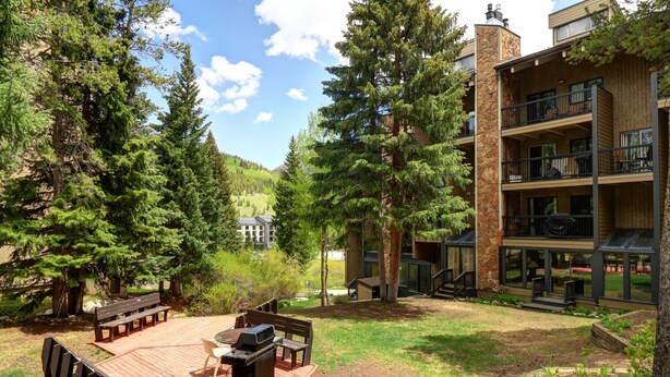 A backyard with a wooden deck, barbecue grill, and outdoor seating. - CM112H Copper Mtn Inn Studio Studio Bedroom 1Bathroom Hotel Room (Copper Mountain)