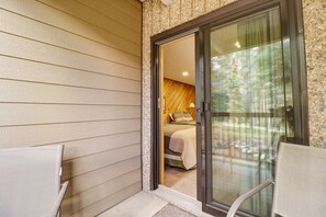 A room with a bed, a chair, and a glass door leading to an outdoor area. - CM112H Copper Mtn Inn Studio Studio Bedroom 1Bathroom Hotel Room (Copper Mountain)