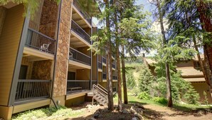 A multi-story building with balconies, surrounded by trees and a stone facade. - CM112H Copper Mtn Inn Studio Studio Bedroom 1Bathroom Hotel Room (Copper Mountain)