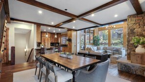 Un salón amplio con una gran mesa de comedor de madera, asientos cómodos y una chimenea de piedra.
