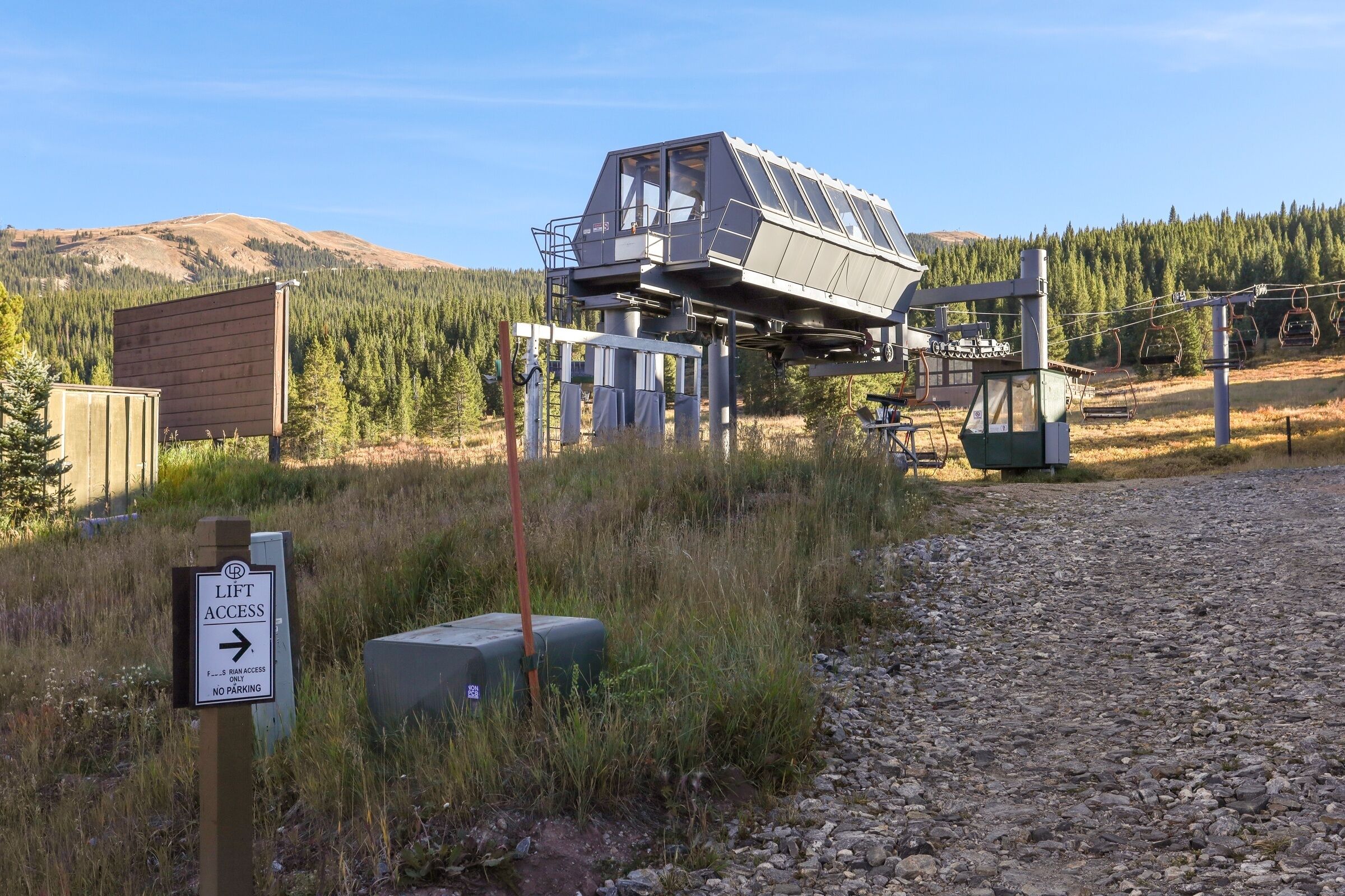 A lift access sign, a wooden structure, and a building with a sloped roof.