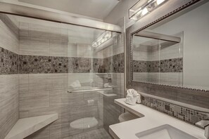 A modern bathroom with a glass-enclosed shower, a vanity with a mirror, and a tiled backsplash. - 241c Mountain Side 2br 2ba 2 Bedroom Condo by RedAwning (Frisco)