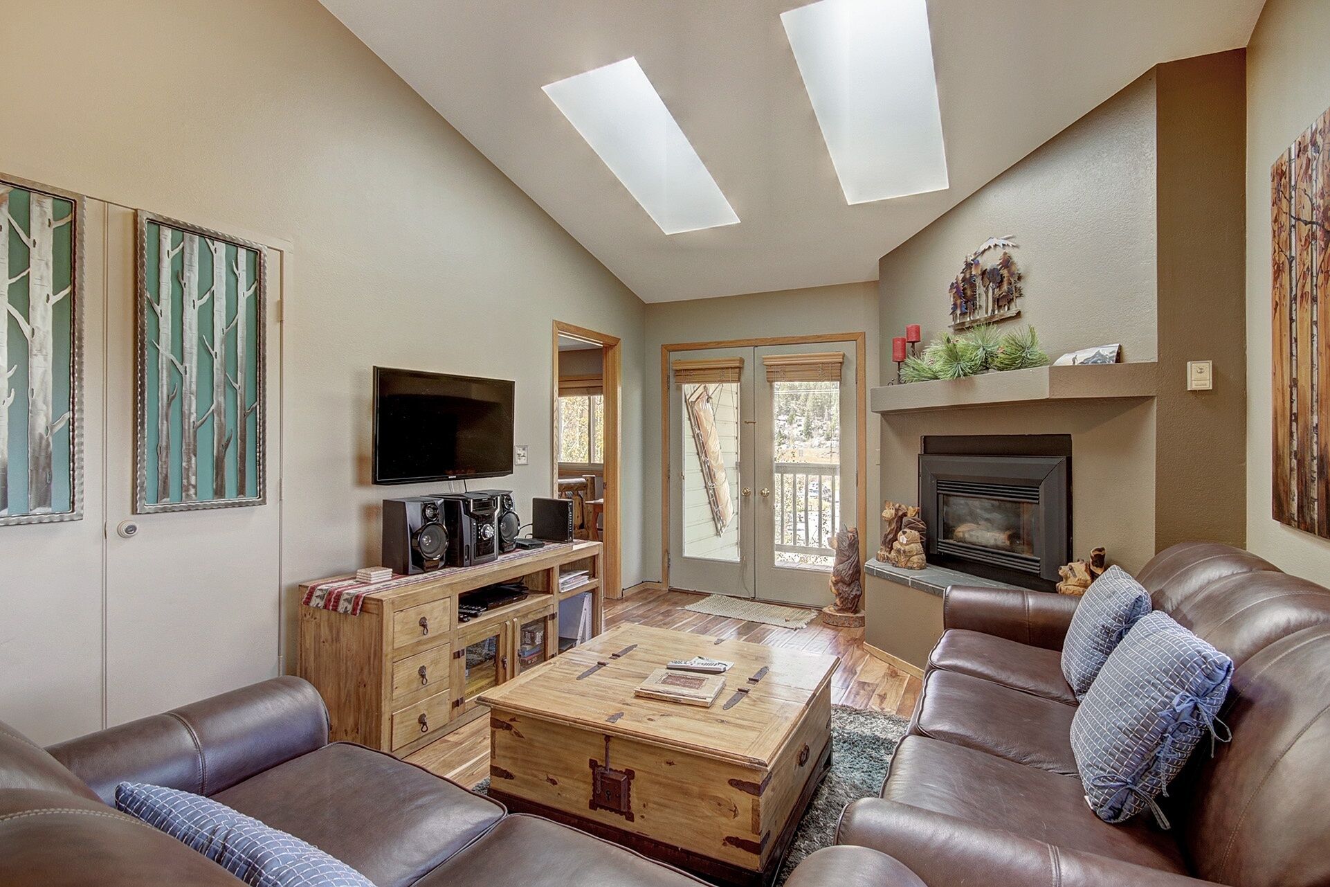 A living room with a fireplace, a television, and a wooden coffee table.