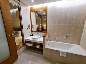 Un baño moderno con bañera, lavamanos y espejo.