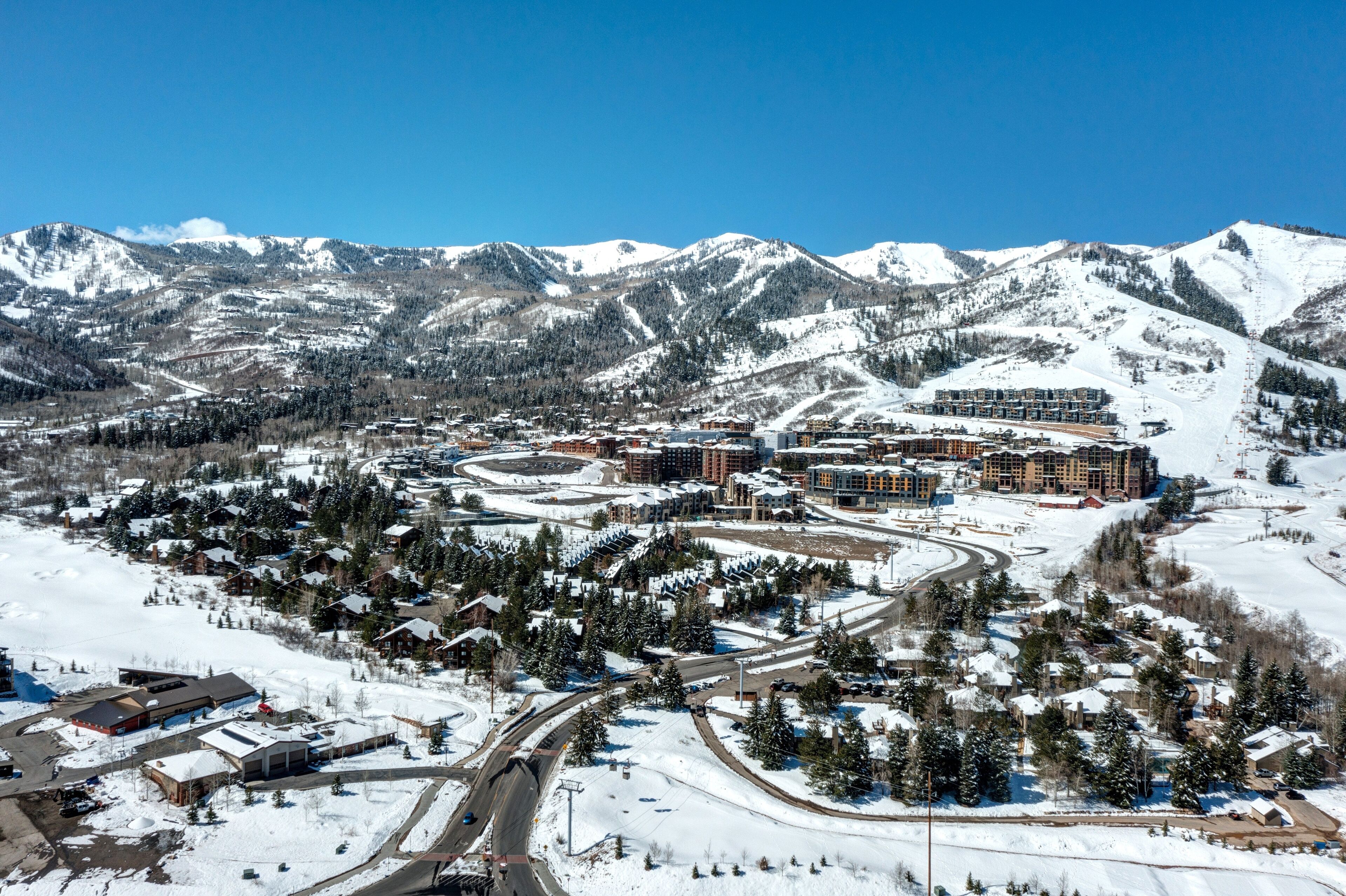 A snow-covered mountain town with a ski resort, including buildings, roads, and ski slopes.