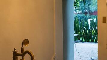 A bathroom with a marble sink and a gold faucet.