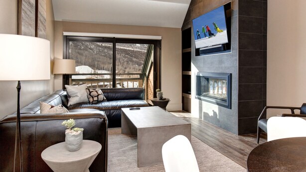 Een moderne woonkamer met een leren bank, een salontafel en een open haard.