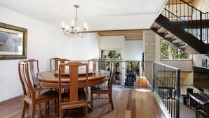 A dining area with a wooden table and chairs, a chandelier, and a staircase leading to an upper level. - 188 Ridgepoint 3 Bedroom Townhouse by RedAwning (Avon)
