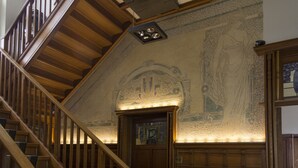A grand staircase with ornate woodwork and a detailed mural on the wall above. - Hotel Shamon (Eeklo)