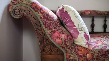 A wooden bed frame with floral upholstery and a decorative headboard.