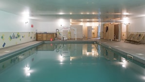 An indoor swimming pool with a clear water surface, a changing room area, and a sauna section. - Greenbanks Hotel (Dereham)