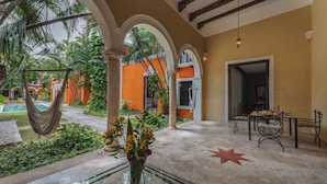 Um espaço amplo interno com piscina, área de estar externa e sala de jantar.