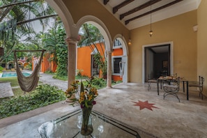 Un amplio espacio interior con piscina, asientos exteriores y zona de comedor.