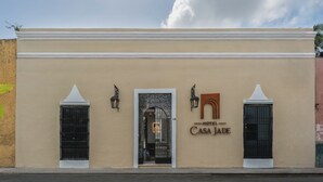 Um edifício com uma placa indicando 'Hotel Casa Jade' e uma grande entrada em arco.