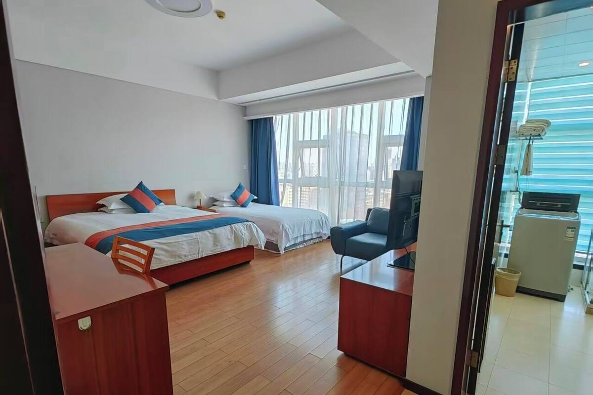 Habitación de hotel con dos camas, un escritorio y una silla.