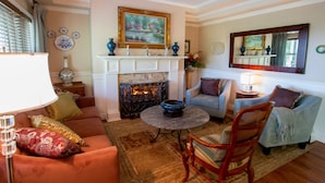 A living room with a fireplace, a sofa, a chair, and a table. - Bald Mountain House Inn at the Wolf Laurel Resort (Mars Hill)