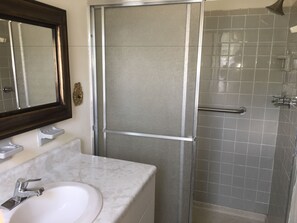 Habitación superior, 1 cama de matrimonio grande | Baño | Ducha, cabezal de ducha tipo lluvia, secador de pelo y toallas