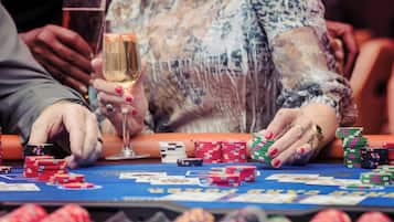 Una mesa de casino con fichas de póker y cartas, indicando que se está jugando una partida de póker.