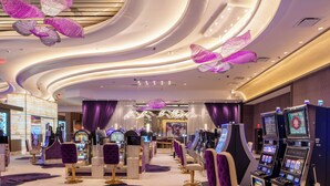 Un intérieur moderne avec des jeux d’arcade, des sièges violets et un éclairage décoratif.