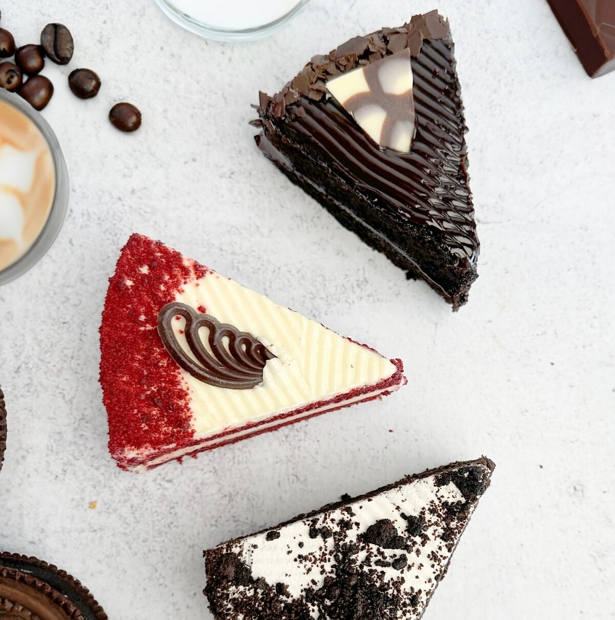 Uma sobremesa com camadas vermelhas e brancas, raspas de chocolate e um pedaço de chocolate em formato de coração.