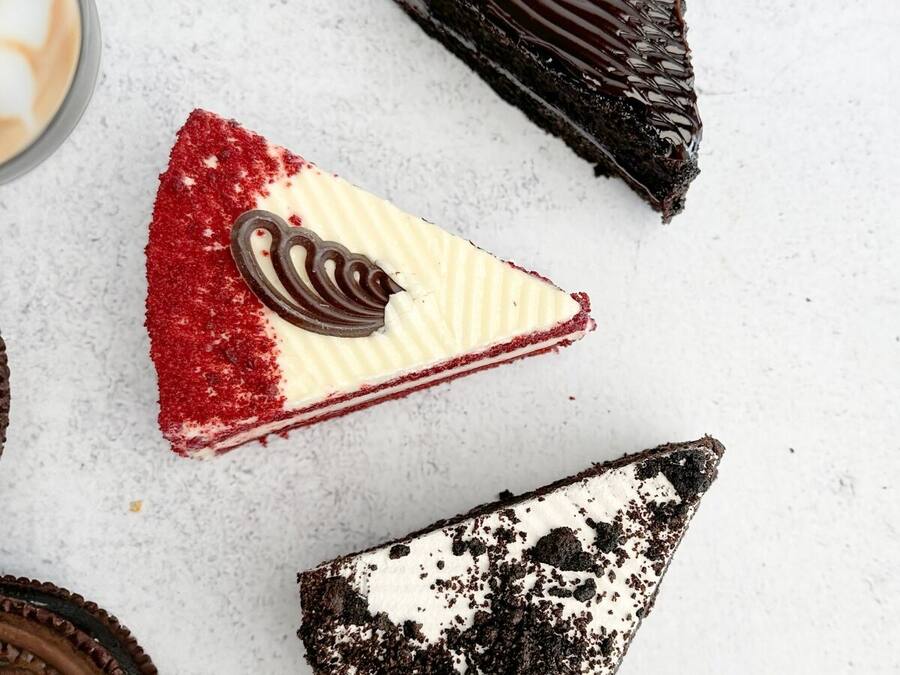 Postre amb capes vermelles i blanques, virutes de xocolata i un tros de xocolata amb forma de cor.