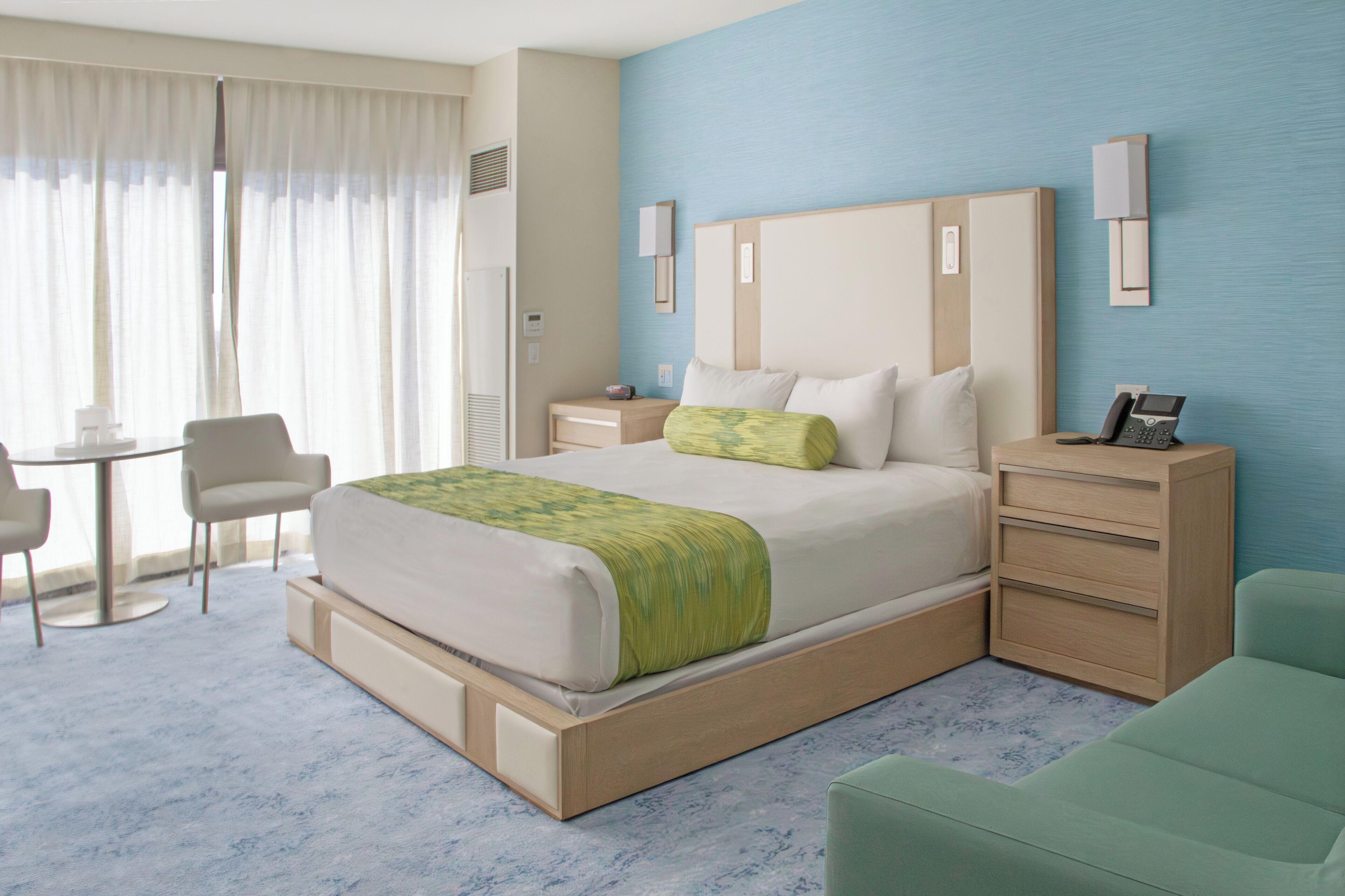 Une chambre d’hôtel comprenant un lit, des tables de chevet, un bureau et une chaise.