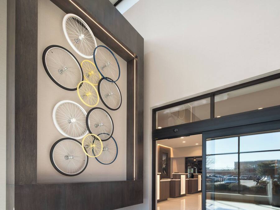 A modern interior with a wall-mounted bicycle wheel art installation.