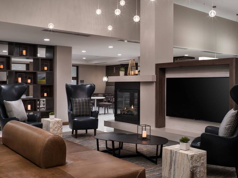A modern lounge area with leather sofas, a fireplace, and a flat-screen TV.