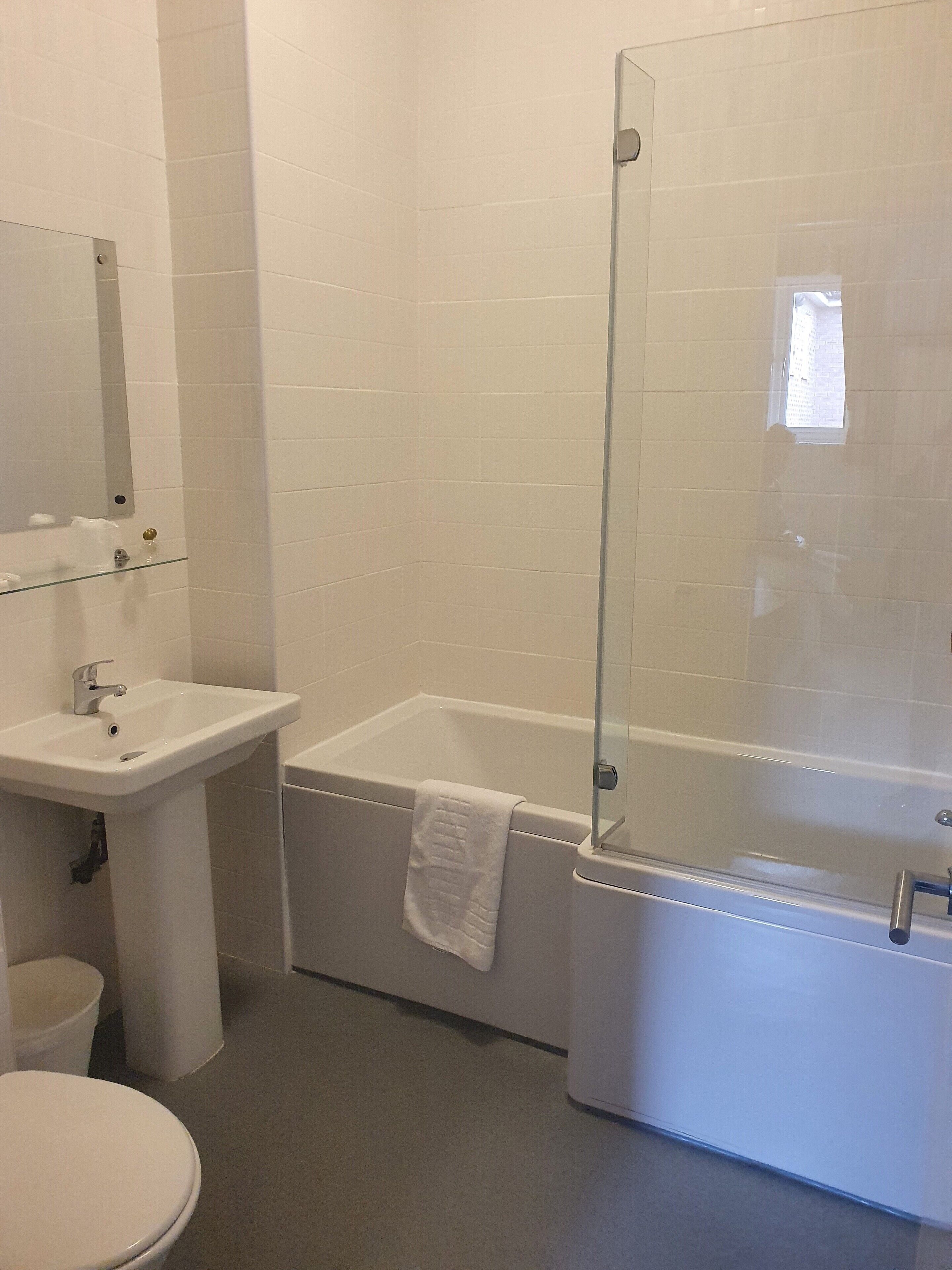 A bathroom with a toilet, sink, and bathtub.