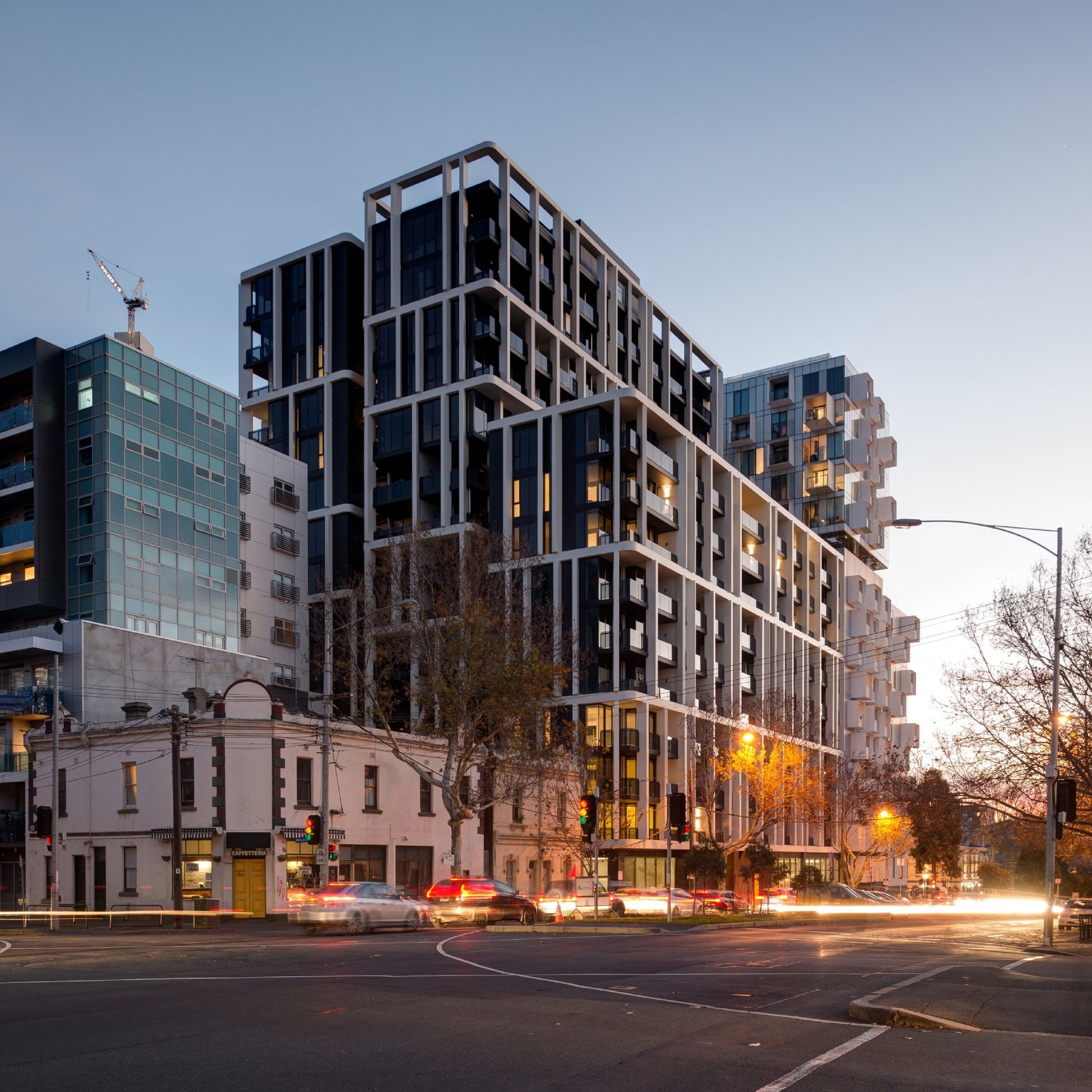 Un immeuble moderne à plusieurs étages, doté d’une façade à motifs géométriques, de grandes fenêtres et de balcons.