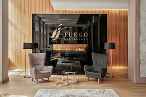 Un interior moderno con chimenea, dos sillones y una mesita.