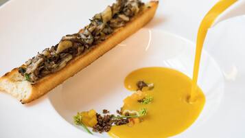 A dish with a bread base topped with mushrooms and a yellow sauce.