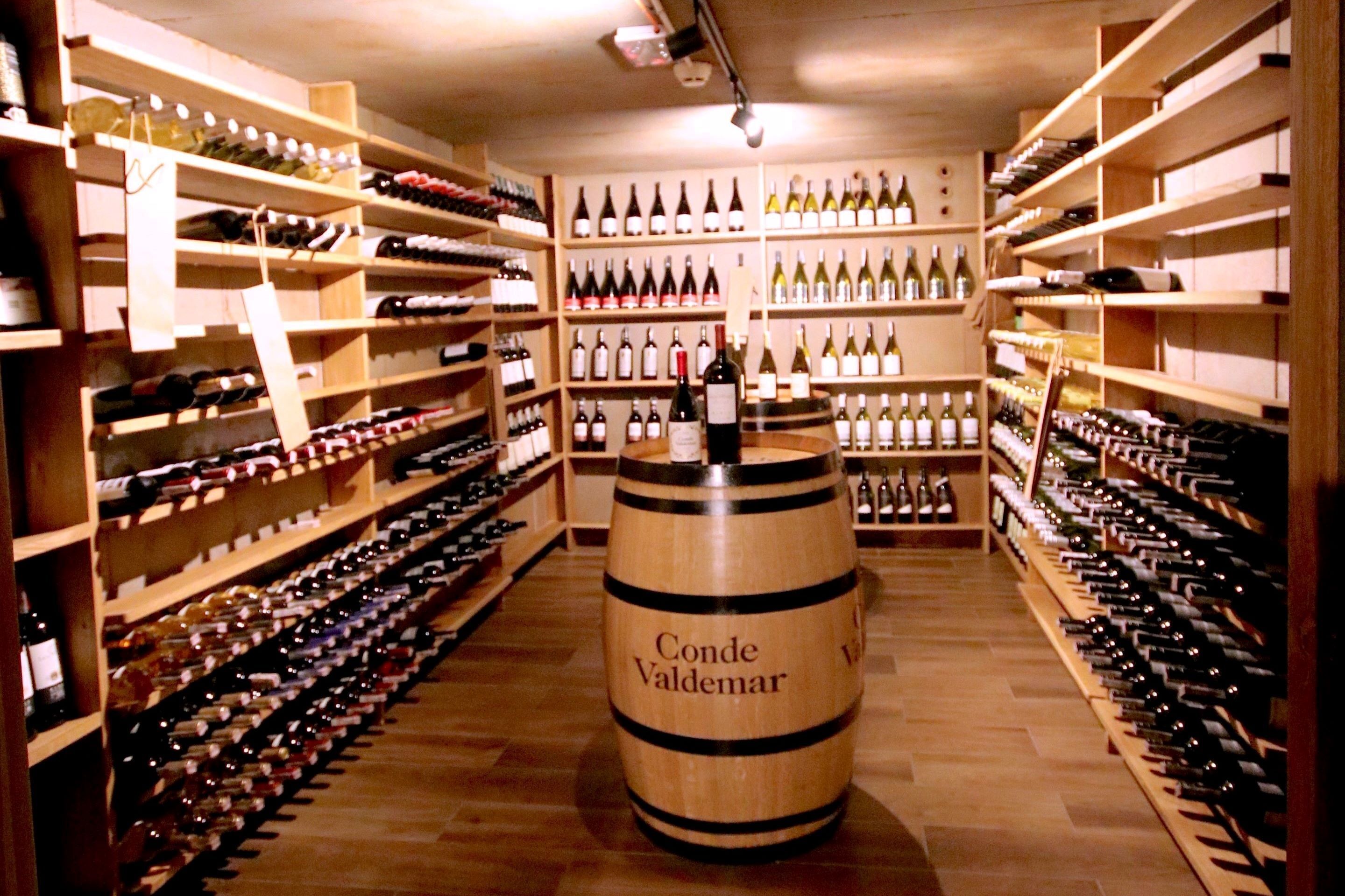 A wine cellar with wooden shelves filled with wine bottles.