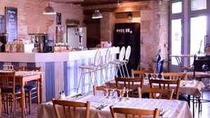 Ein Restaurant mit Ziegelwänden, Holztischen und -stühlen sowie einer Bar.