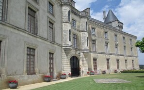 Un grand bâtiment historique à la façade symétrique, doté de nombreuses fenêtres et d’une entrée centrale.