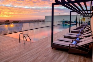 Una piscina al aire libre, sillones reclinables de piscina