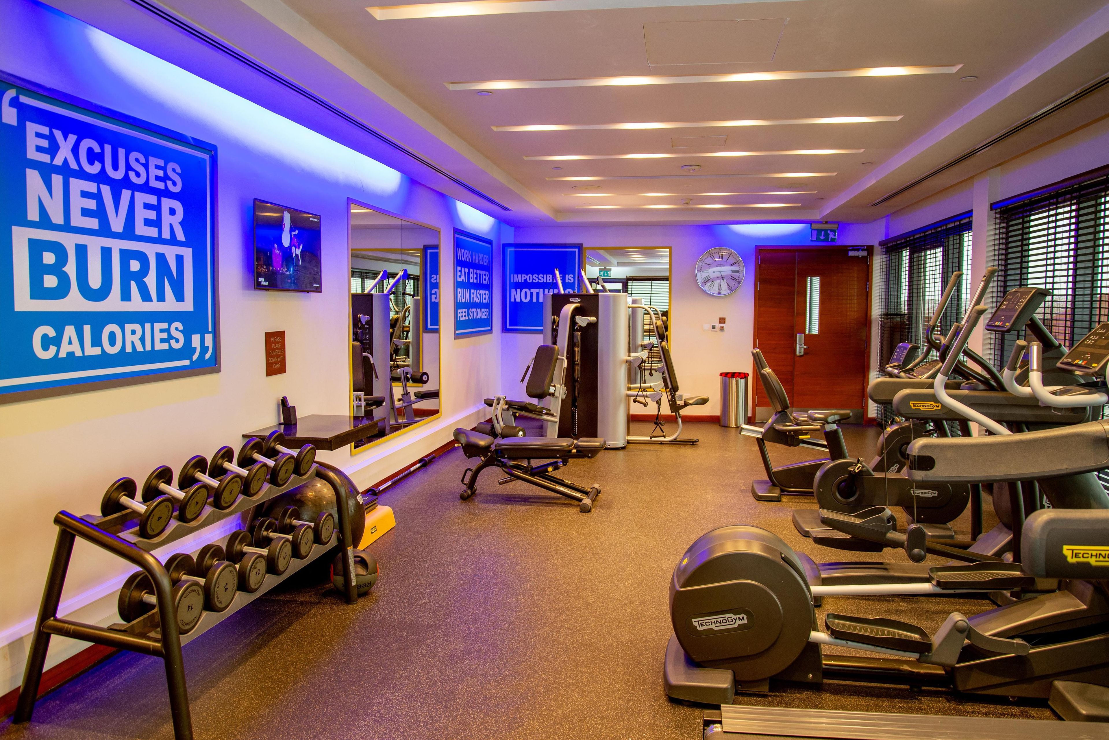 Una palestra con tapis roulant, ellittiche e attrezzature per pesi.