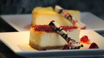 A dessert plate with a slice of cheesecake topped with berries and chocolate shavings.