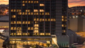 A multi-story hotel with a grid of windows, a ground-level restaurant, and a parking area. - Hyatt House Gebze (Gebze)