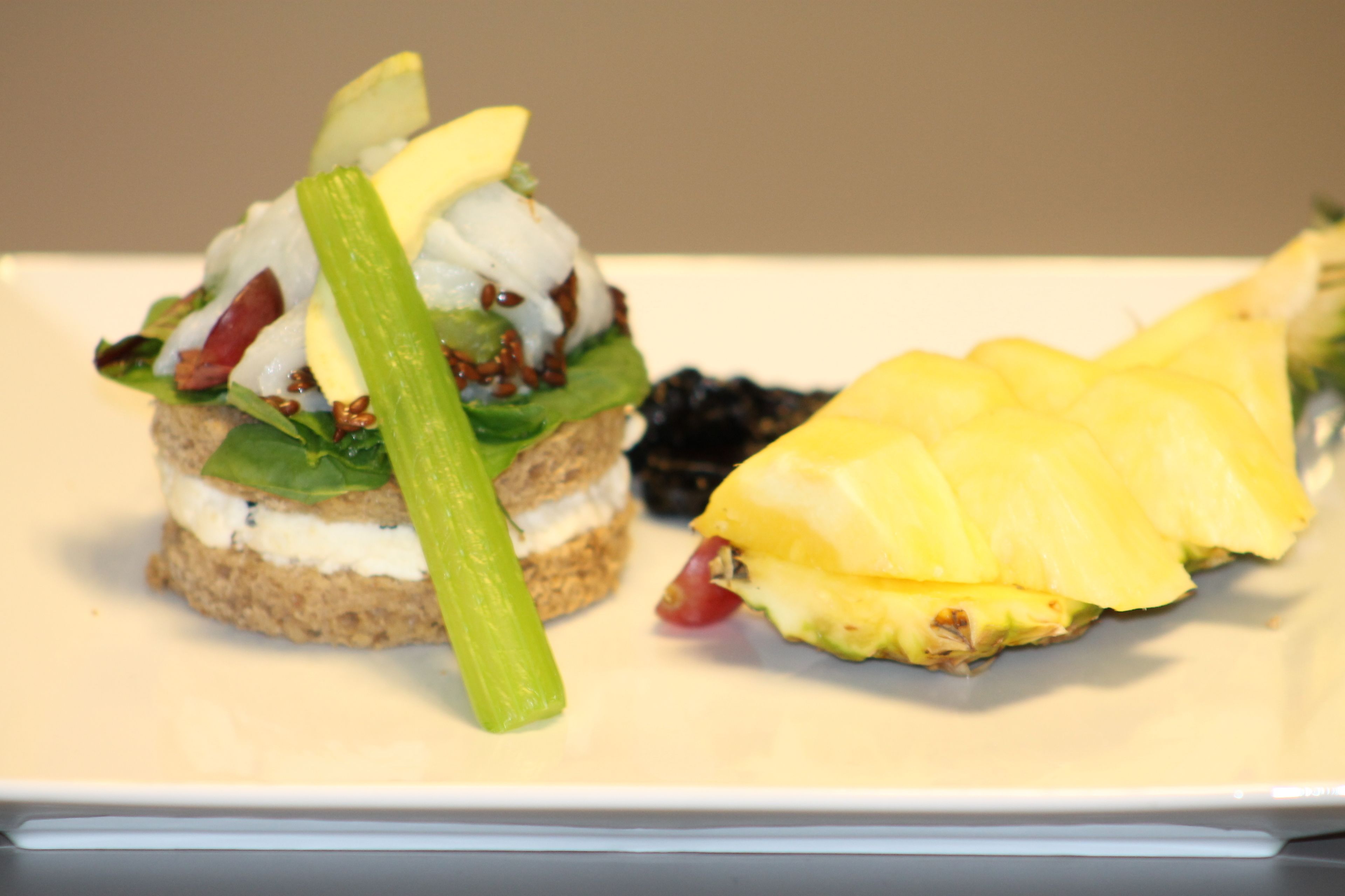 A sandwich with lettuce, tomato, and cheese on a white plate.