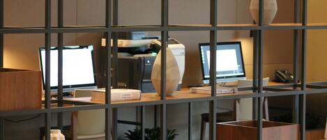 A modern office space with multiple computer monitors, wooden furniture, and decorative vases.