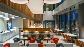 A modern hotel lobby with a central bar area, seating arrangements, and large windows. - Hyatt House Gebze (Gebze)