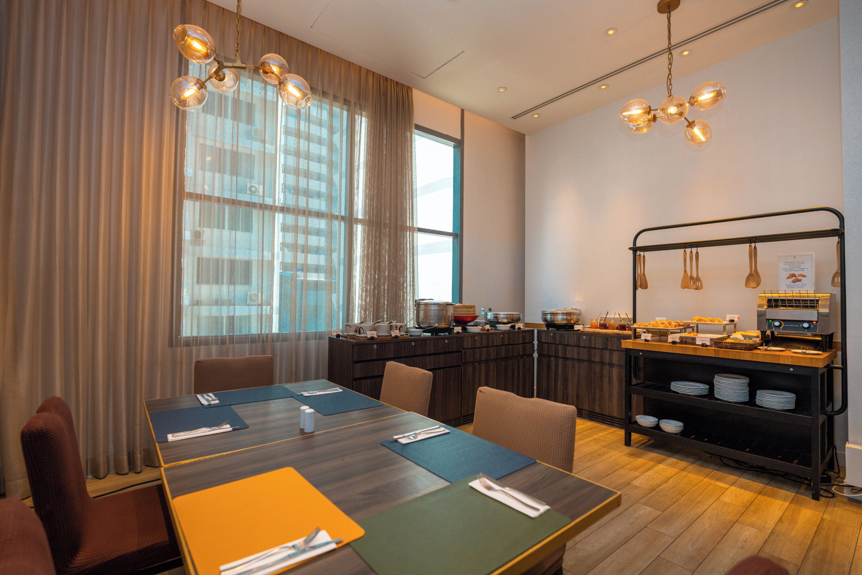 Een moderne vergaderruimte met een lange tafel, stoelen en een kitchenette met een buffet.