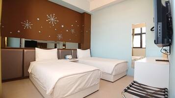 A hotel room with two beds, a desk, a chair, a TV, and a mirror.