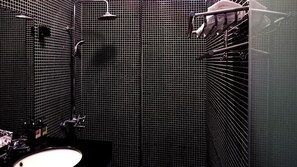 A bathroom with a sink, mirror, shower, and towel rack.
