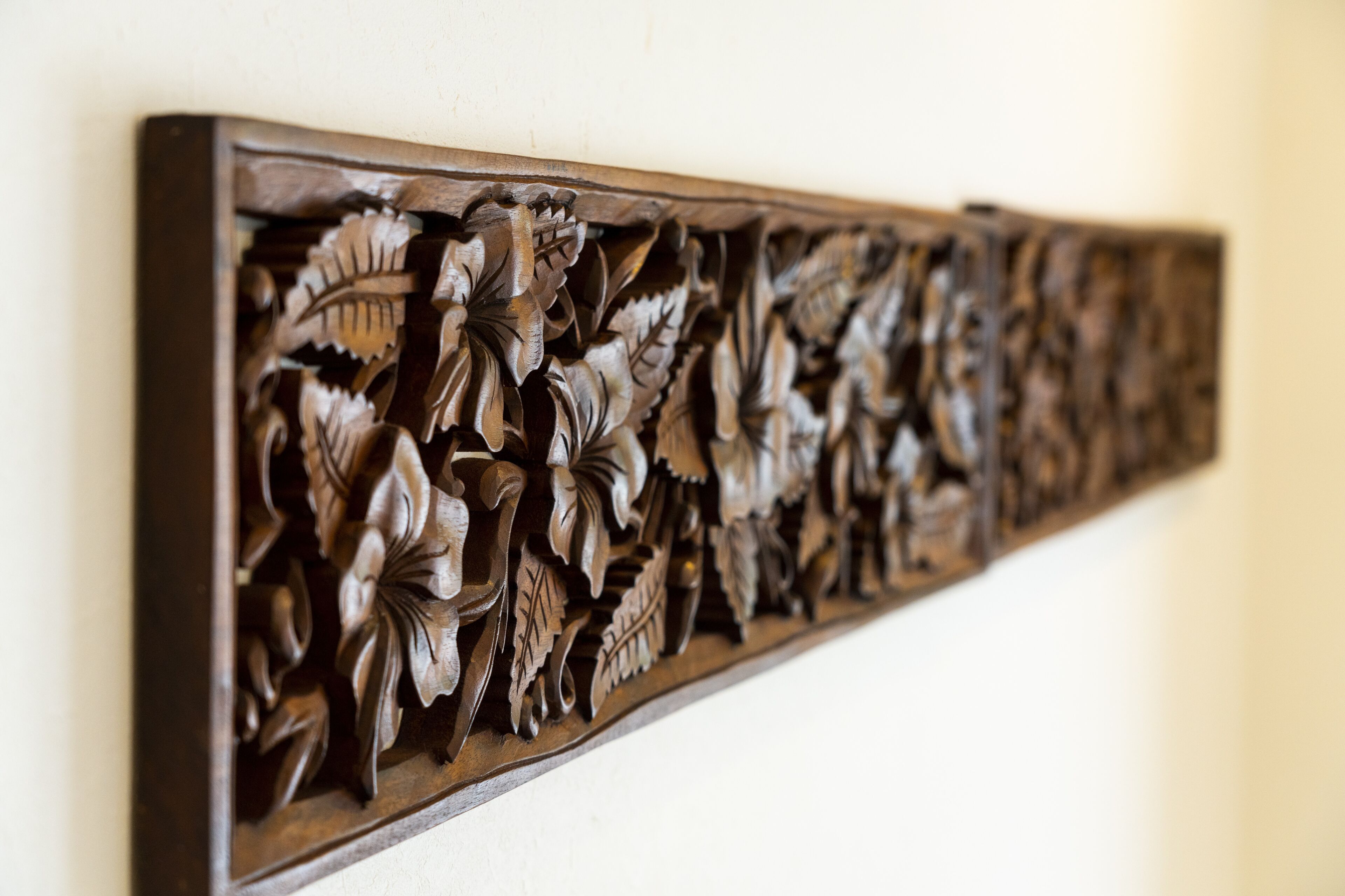 A detailed wooden carving with floral and leaf motifs.