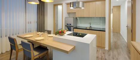 A modern kitchen with a central island, wooden cabinetry, and pendant lighting.