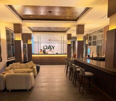 A hotel lobby with a reception desk, seating area, and a bar.
