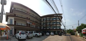 Un immeuble à plusieurs étages doté d’une façade incurvée, de nombreux balcons et d’une enseigne sur laquelle on peut lire « THE GRAND ».