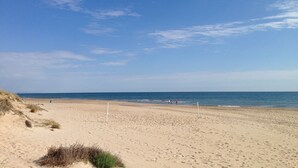 A wide sandy beach with footprints and a volleyball net. - Beautiful apartment near the beach with a view of the pool and the mountain 'Segaria' (El Verger)
